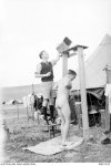 7. 1944 Italy. Flight Sergeant E. A. Walker of Minyip, Vic, assists his friend to take a %22ho...JPG