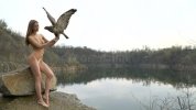 naked-girl-bird-near-lake-quarry-stands-cloudy-day-90647599.jpg