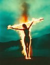 a burning naked woman, crucified on a burning cross, burning in a fire.jpg