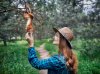 young-woman-in-hat-with-long-hair-feeding-funny-squirrel-in-pine-forest.jpg